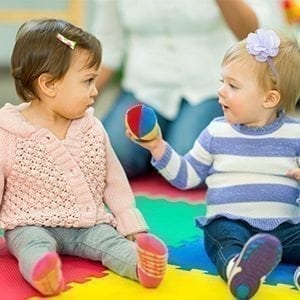 Baby erkundet den Montessori Greifball auf der Krabbeldecke