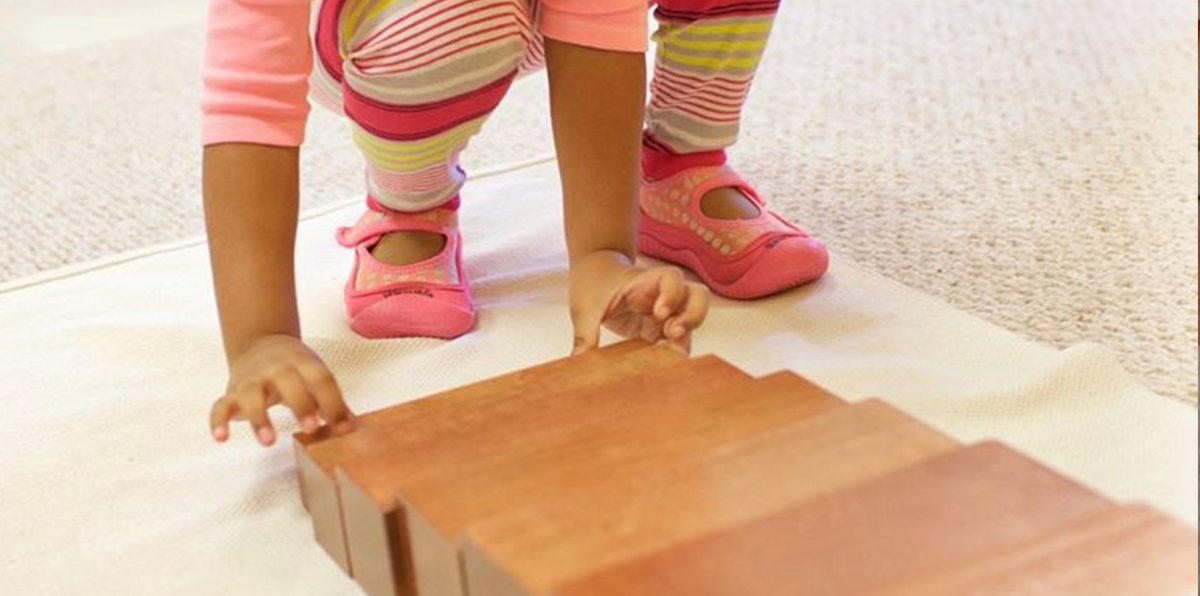 Kind beim Hantieren mit den Holzprismen der Braunen Treppe