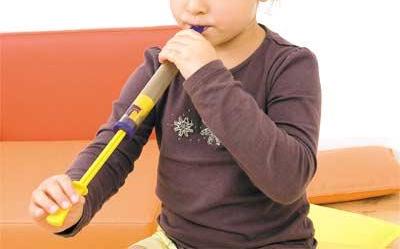 Kleinkind spielt auf der Montessori Holz-Ziehpfeife