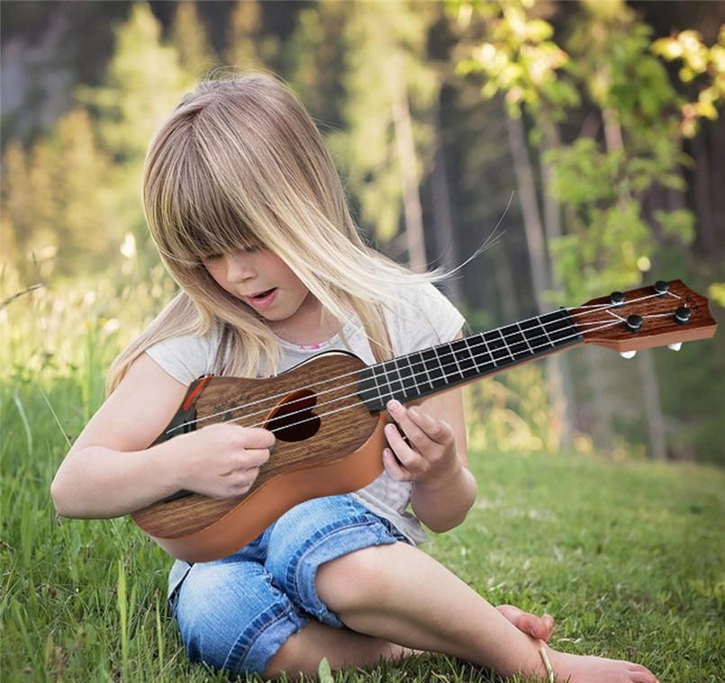 Kind spielt auf einer akustischen Holzgitarre nach Montessori mit Nylonsaiten